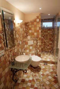 WC im Antoni Gaudí-Stil mit erdfarbenen Mosaik-Fliesen