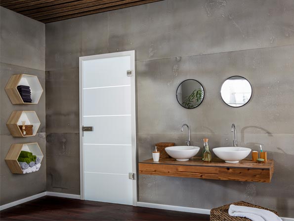 Zimmertüre aus Milchglas in einem Badezimmer mit grauen XXL-Wandfliesen