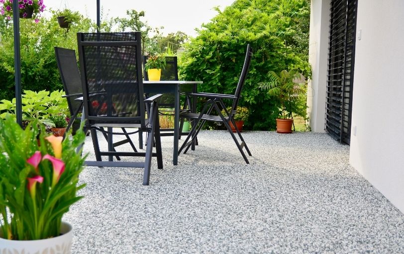 Schwarze Terrassenmöbel auf einem schwarz-weißen Natursteinboden